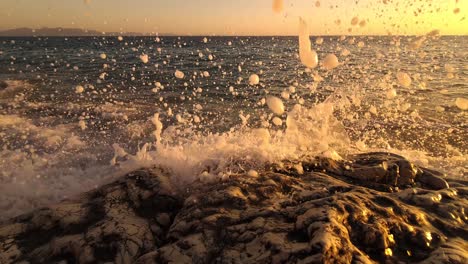 sea waves splashing and foaming on carved rock at golden hour of twilight, beautiful romantic spiritual moments on shore of mediterranean