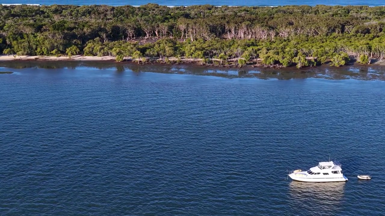 Ripresa aerea con drone di uno yacht di lusso ancorato vicino a lussureggianti mangrovie sull'isola di South Stradbroke
