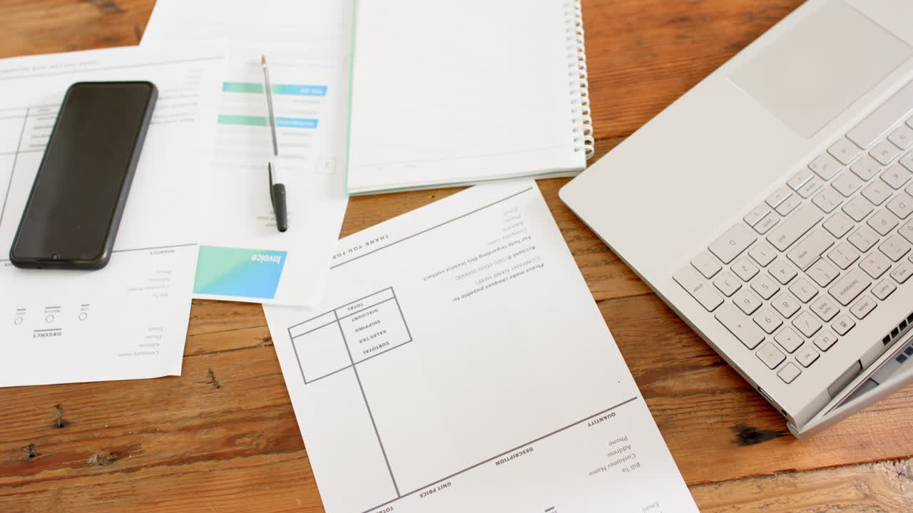 papelería, bolígrafo, teléfono inteligente y portátil en la mesa en una habitación soleada en casa, cámara lenta