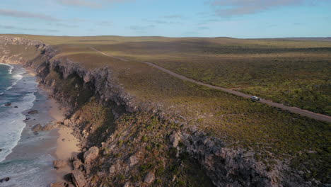 Aerial-view-following-a-RV,-driving-on-the-shore-of-Kangaroo-island,-in-Australia,-sunny-day---tracking,-drone-shot