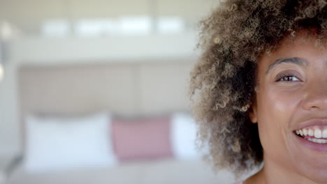 smiling woman with curly hair in cozy home environment, feeling happy, copy space