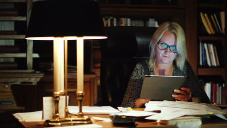 business woman with tablet in study at night