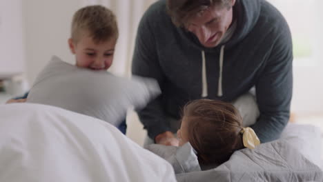 happy family with children jumping on bed playing with mother and father having fun on weekend morning excited little kids enjoying game with parents at home 4k footage