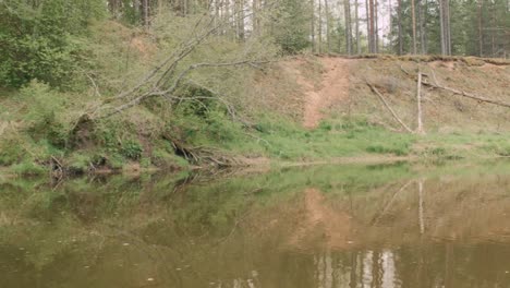 View-from-boat---guy-rowing-in-a-wild,-slow-river-in-a-canoe