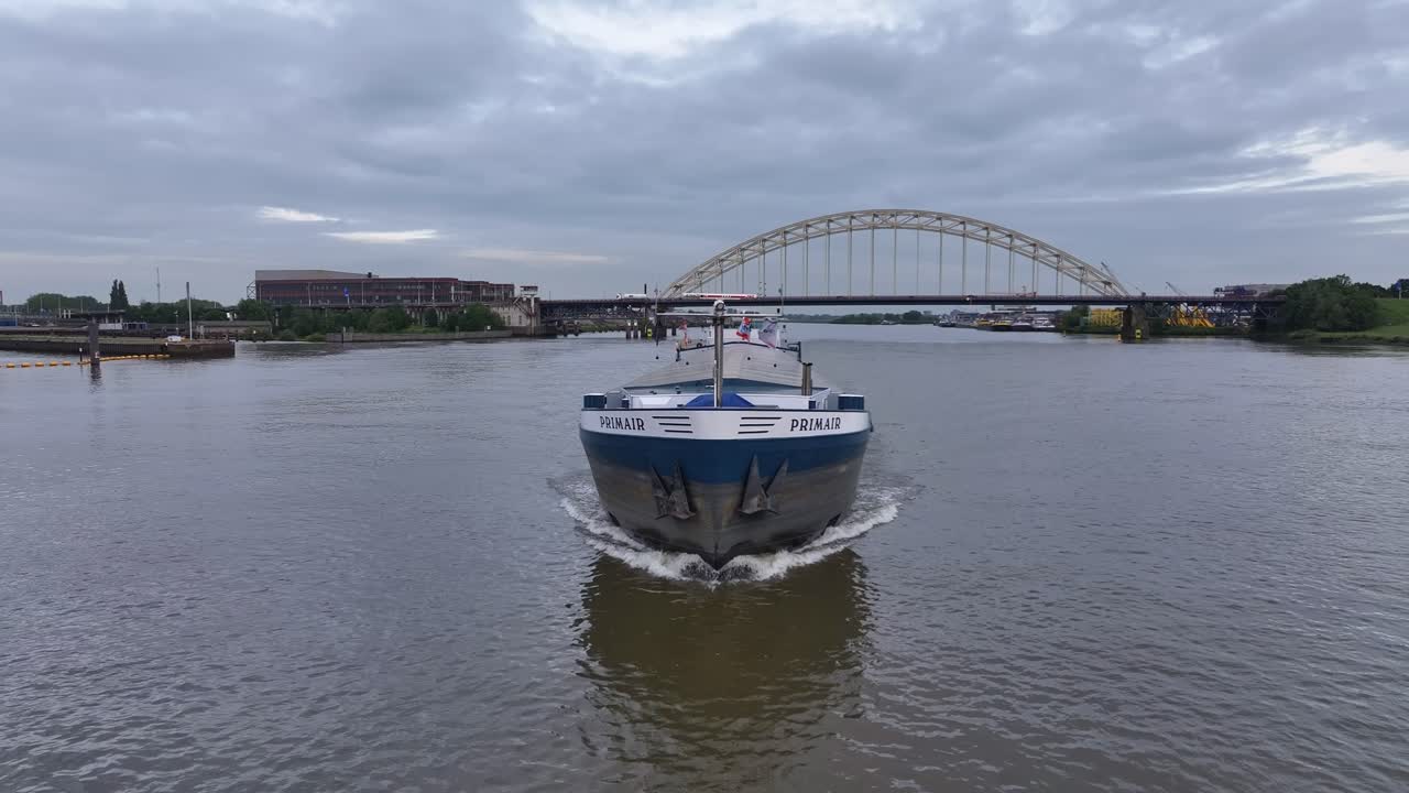 Cargo ship on a river with a bridge