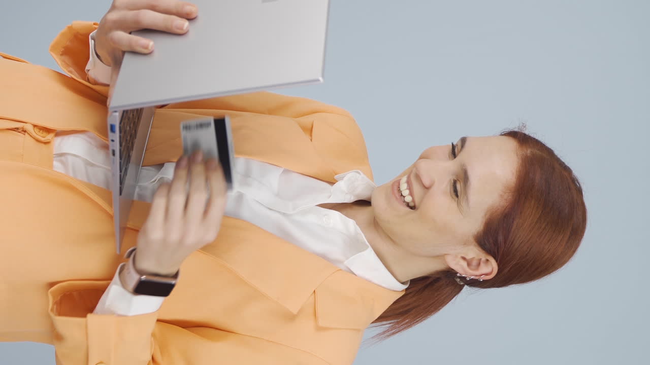 вертикальное видео деловой женщины, делающей покупки по телефону с кредитной картой.