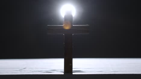 concepto religioso filmado con cruz de madera en el altar con foco detrás 1