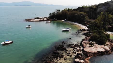 Aerial-flyover-tropical-bay-with-anchored-boats-at-Florianopolis-Island,Brazil