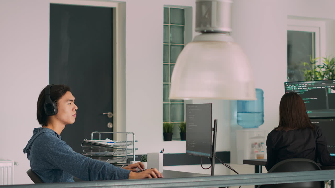 Asian web developer programming firewall server on terminal window