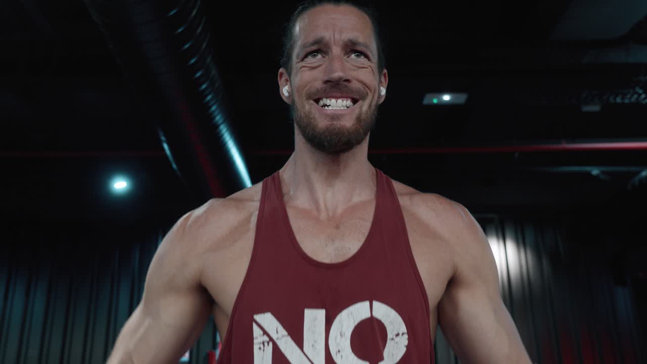 Primer plano de un atleta esforzándose y haciendo una mueca mientras hace ejercicio