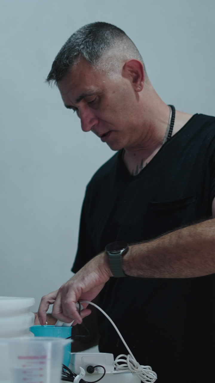 Man Focused on Connecting Cables and Working with Equipment