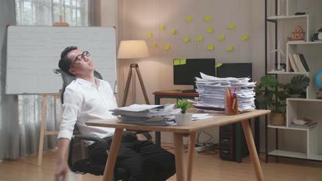 un hombre de negocios sobrecargado de trabajo tomando una siesta en su escritorio.