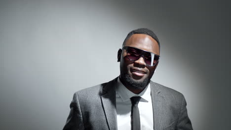 studio portrait of cheerful black businessman in sunglasses