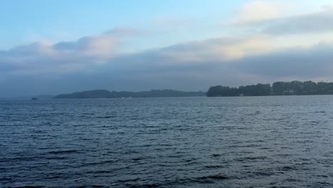 Beautiful-dolly-in-aerial-drone-shot-of-the-stunning-man-made-Guarapiranga-Reservoir-in-the-south-part-of-São-Paulo,-Brazil-with-calm-waters,-beaches,-marinas,-and-wildlife-on-a-cloudy-fall-evening