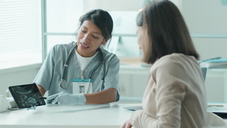 midwife telling about ultrasound scan to pregnant woman