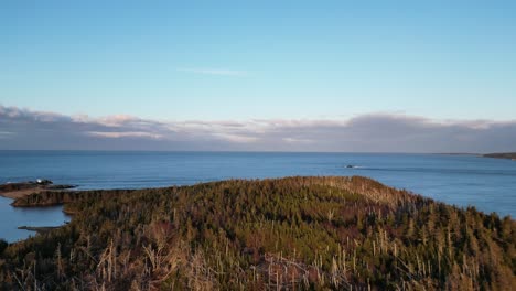 a fly over of mira bay from scatarie island, flying towards a small town over looking the ocean