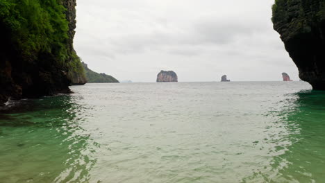 aerial shot flying over beach and waves to sea in krabi, thailand