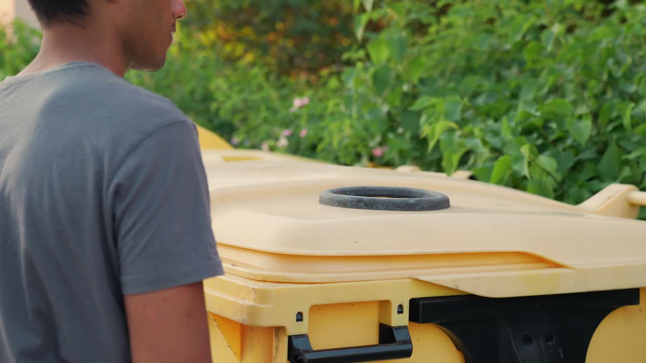 niño migrante responsable de sri lanka desechando plástico en una papelera de reciclaje