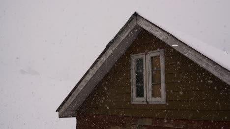 Los-Copos-De-Nieve-Flotan-Suavemente-Junto-A-La-Ventana-Del-ático-En-Gulmarg,-Cachemira,-India---Plano-Medio