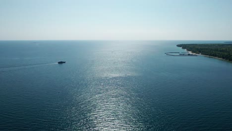 Drone-shot-of-a-ferry-carrying-cars-and-people-in-door-county,-Wisconsin