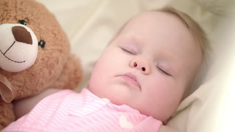 Adorable-baby-sleeping-in-bed.-Portrait-of-sleeping-baby-with-toy-bear