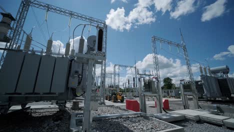 many high voltage electrical insulators in power substation against blue sky background