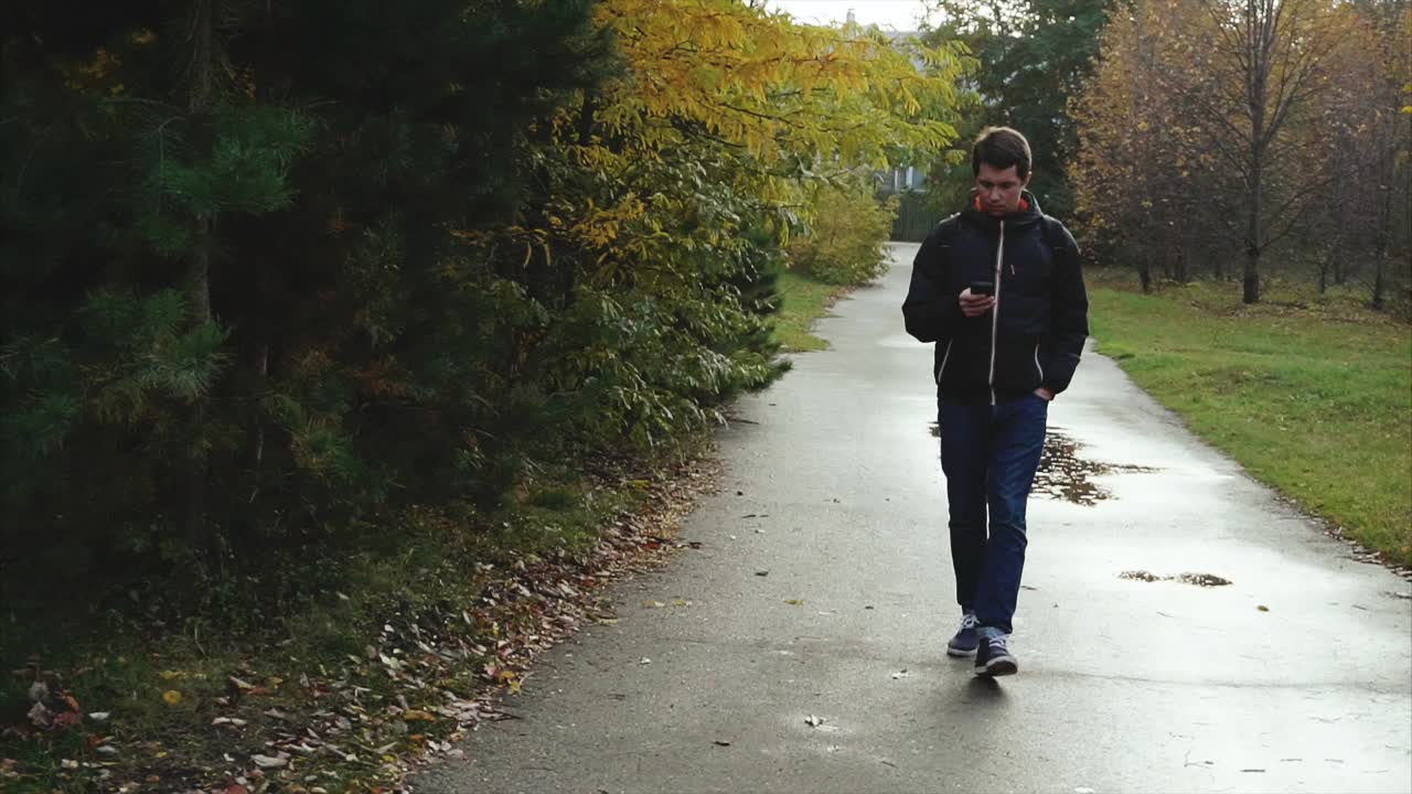 Man Walking in Park on a Rainy Autumn Day
