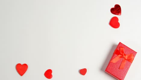 Rote-Geschenkbox-Und-Rote-Herzen-Auf-Weißer-Oberfläche-4k