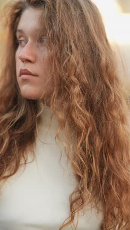 close-up portrait of a young woman with curly red hair