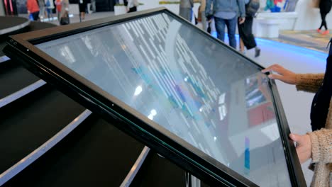 woman using interactive touchscreen display at urban exhibition