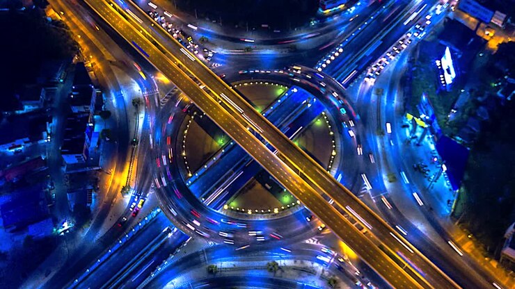 Vista aerea sfocata del traffico su rotonda, autostrada e svincolo di notte