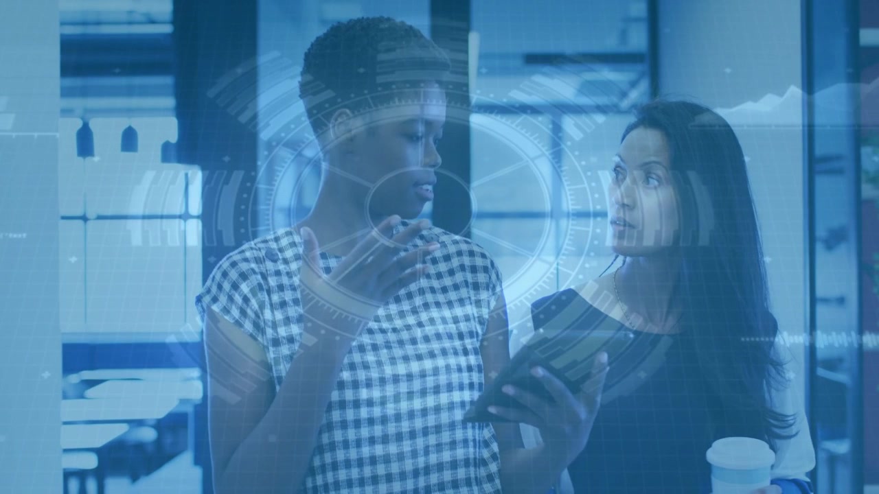 Left woman presenting tablet, activating tech AR UI waveform while peer leaning and reviewing work