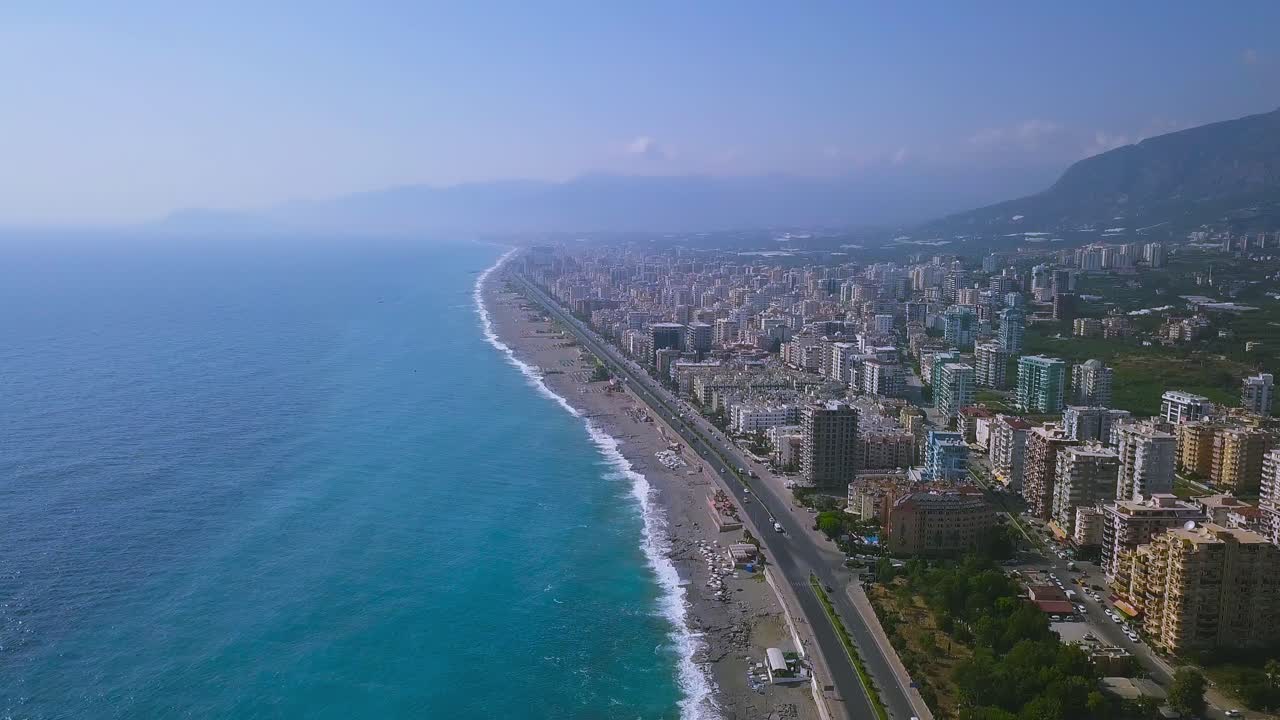 paisaje urbano costero con océano azul y montañas