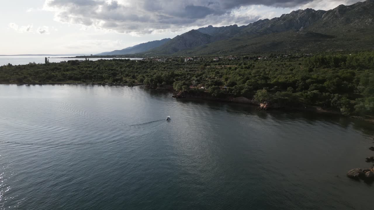 красивое каменное побережье океана с большими горами на заднем плане в золотой час