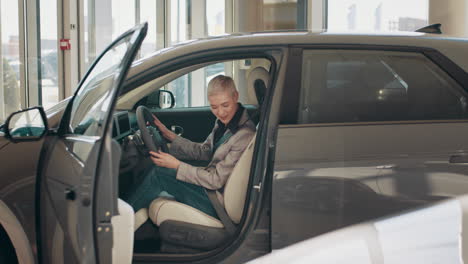 woman test-driving a new electric car in a showroom