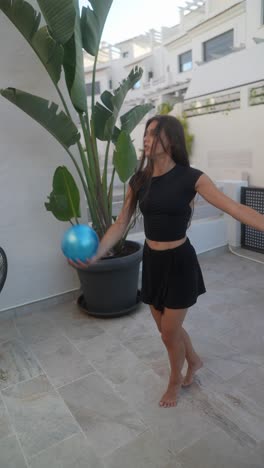 teen girl playing with a balloon on a patio