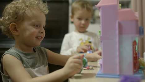 twee kleine jongens die thuis met speelgoed spelen