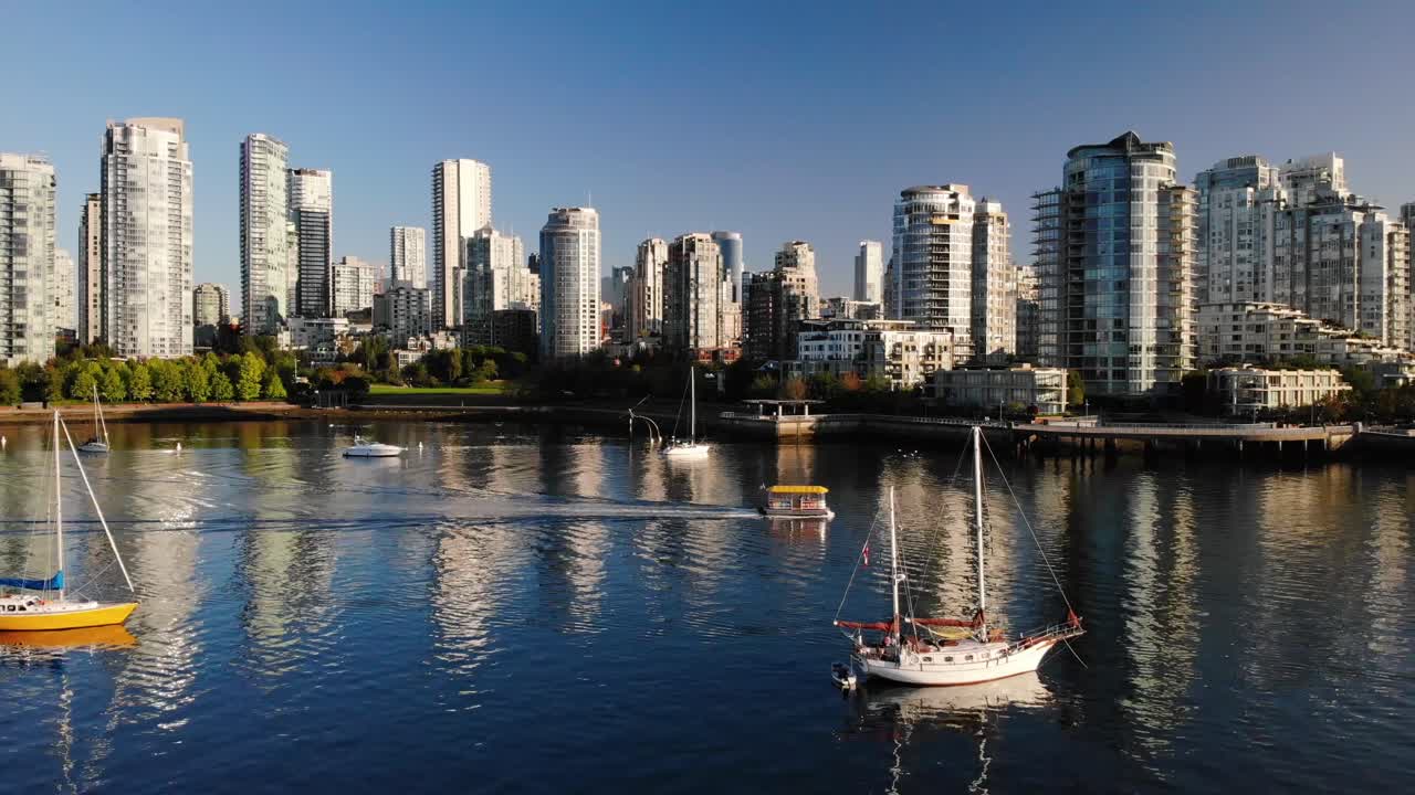 4K Footage of Boat Docked to a Harbor with the beautiful background of the Vancouver City Landscape. Motion Upwards across the water and the reflections.