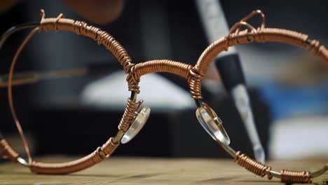 crafting unique wire frame glasses: an artistic process showcased through two distinct frames capturing the intricate details of handmade eyewear