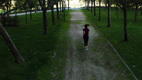 Aerial-shot-of-a-woman-running-away-from-camera-in-Enrique-Tierno-Galván-Park