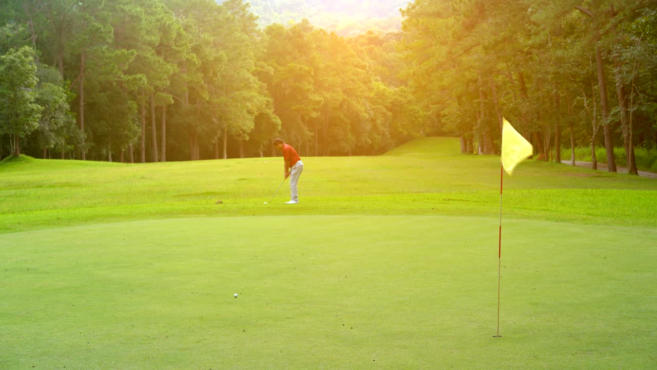 골프 스포츠 개념, 골퍼 느린 동작  골프 공은 우승자를 위해 그린에 구을. 골프 코스는 아름다운 페어웨이와 산에 자연 나무에 레이아웃