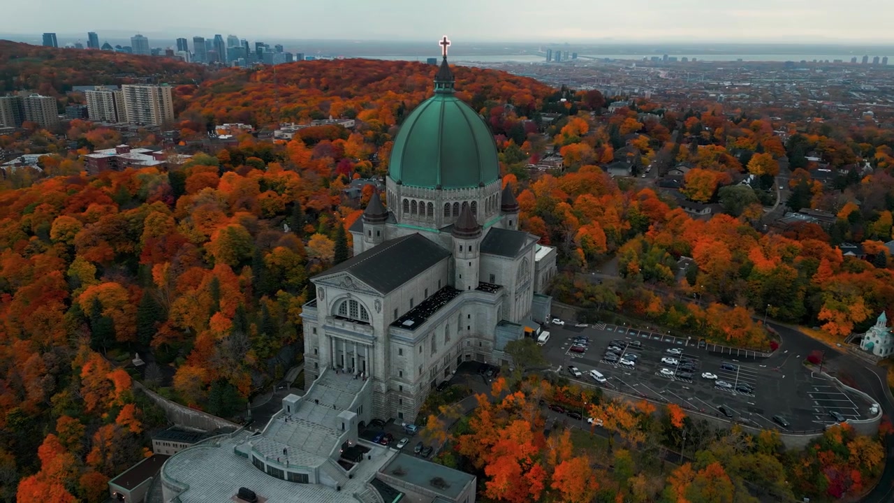 Luftaufnahme um das Saint-Josephs-Oratorium in Montreal, die die Stadtsilhouette im Hintergrund und die farbenprächtige Herbstlandschaft der Provinz Québec, Kanada, zeigt.