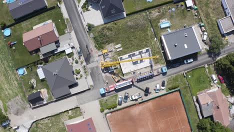 mobile crane building modular house at construction site in suburbs