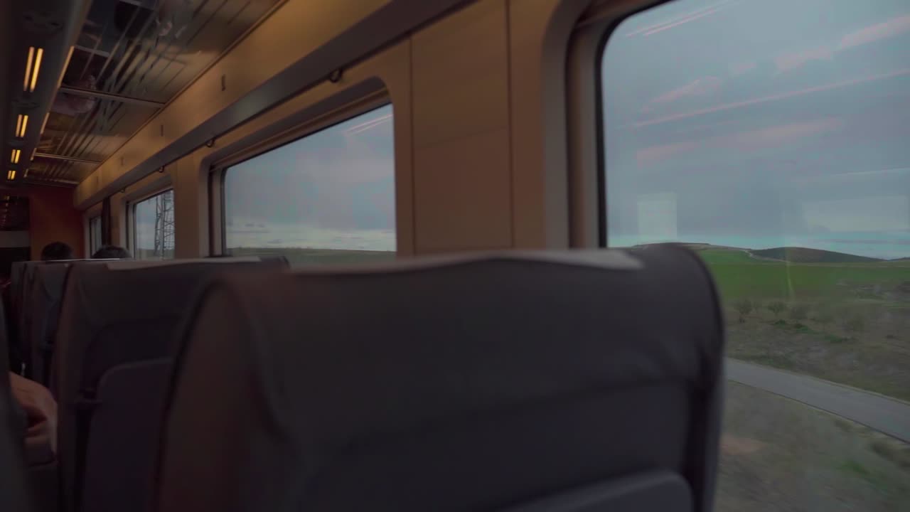 POV passeggero dall'interno del treno che guarda fuori dal finestrino durante il viaggio.