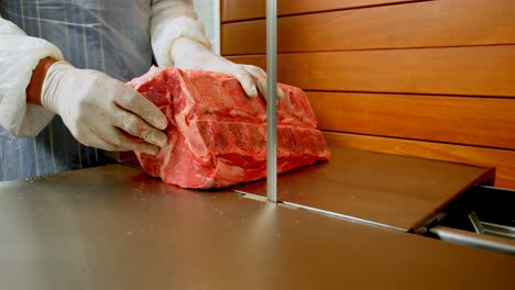 butcher cutting meat on meat cutting machine in shop 4k