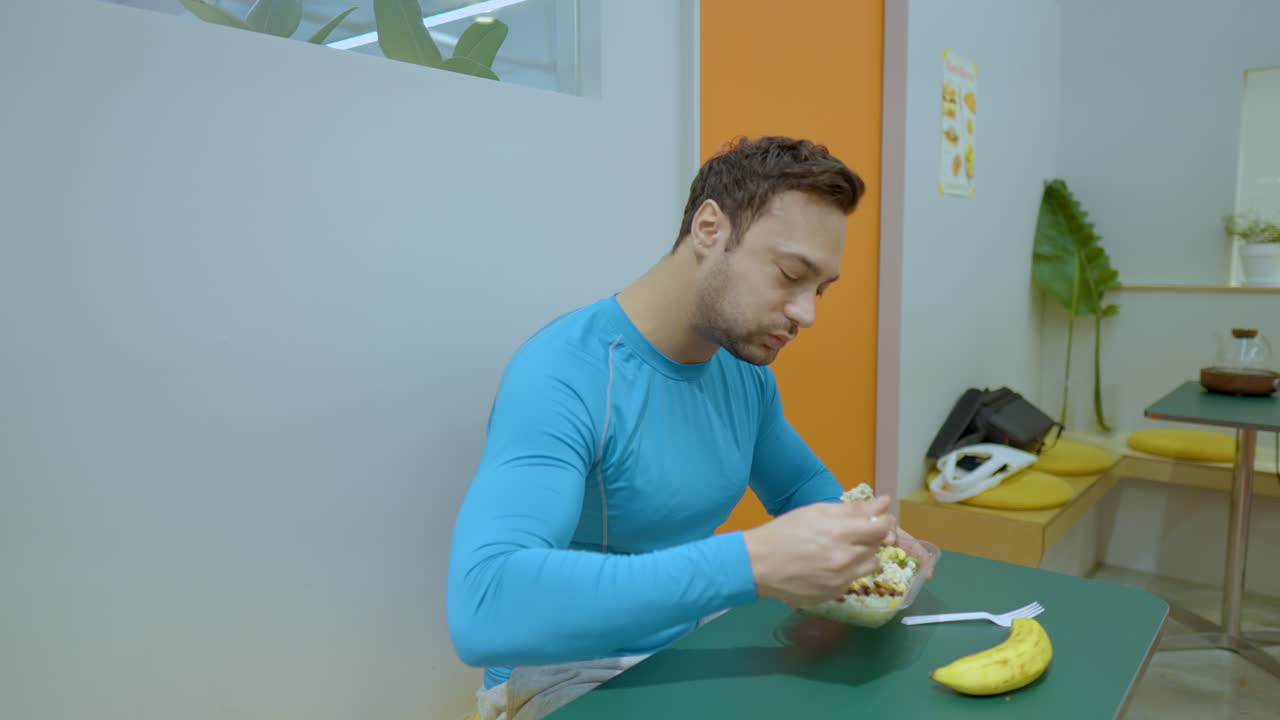 hombre feliz en forma disfruta de ensalada fresca después del ejercicio