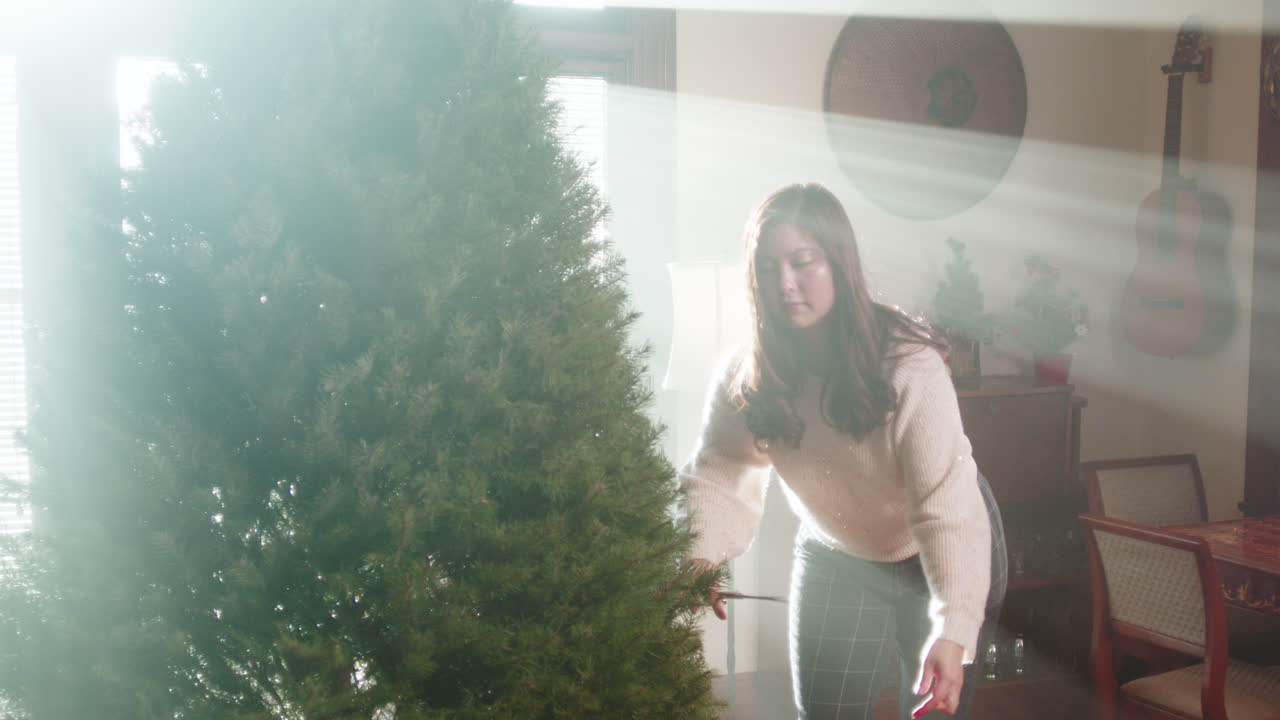 Woman Decorating a Christmas Tree Indoors