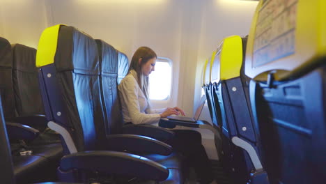 mujer trabajando en una computadora portátil en un avión