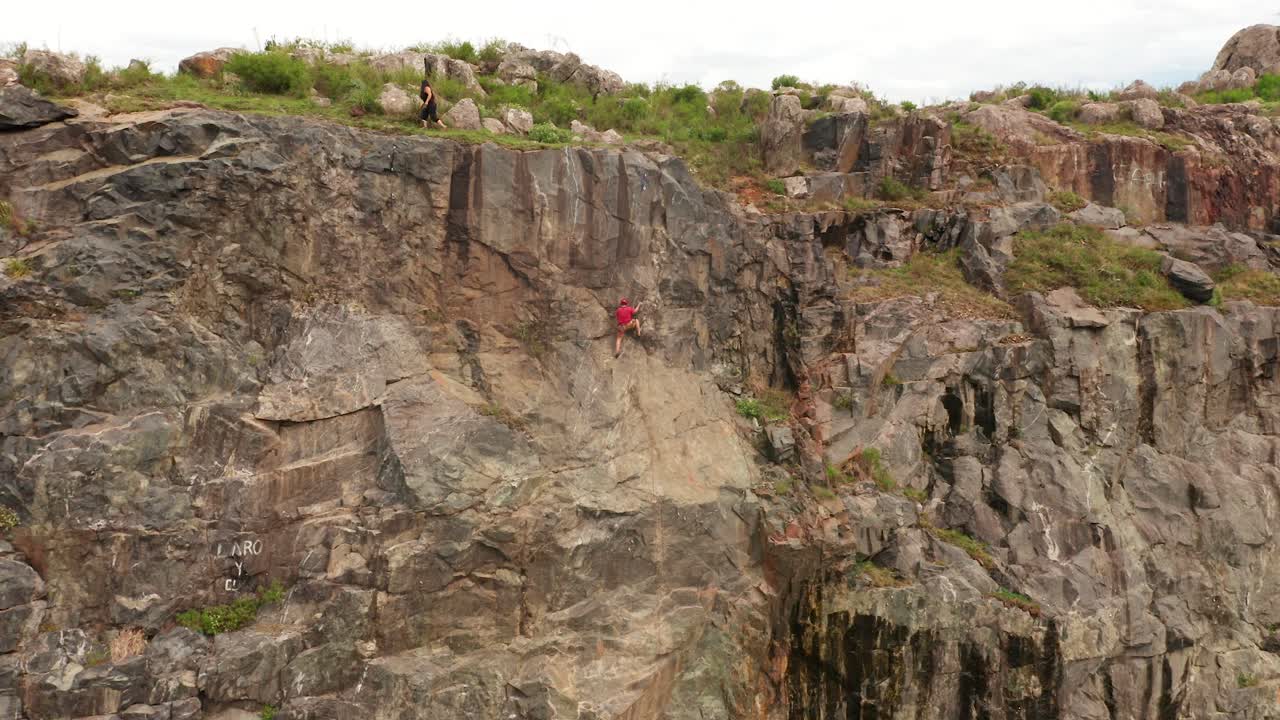 un video de alejamiento de un hombre escalando una montaña
