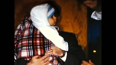 man holding baby in his arms. circa usa - 1970s: a man from a 1970s video archive in the usa holds a baby in a heartwarming embrace.